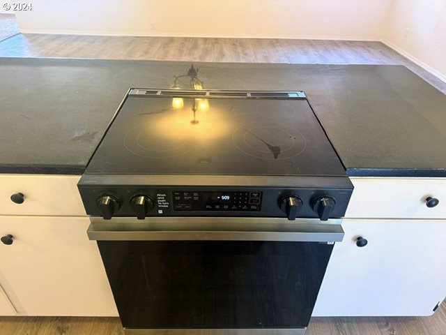 interior details with hardwood / wood-style floors and high end stainless steel range oven