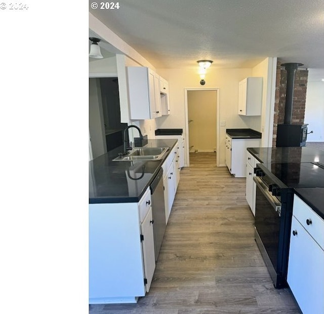 kitchen featuring white cabinetry, sink, light wood-type flooring, and appliances with stainless steel finishes