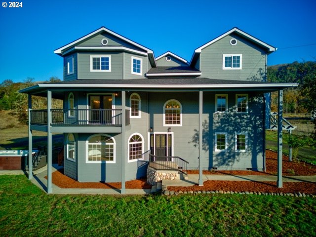 view of front facade featuring a front yard and a balcony