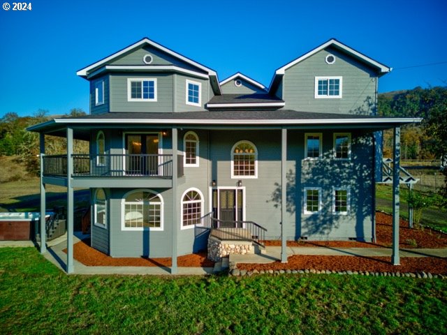 1381 Echo Dr, Roseburg, OR 97470 - view of front facade with a balcony, a hot tub, a front yard, and a patio