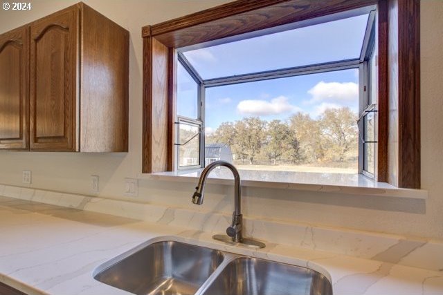 interior details with sink and light stone countertops