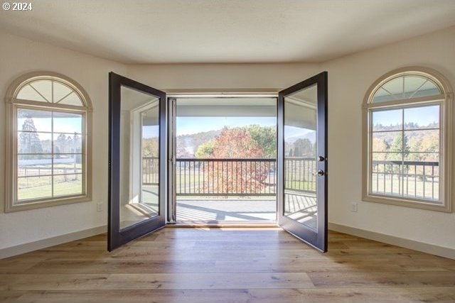 doorway to outside with french doors and light wood-type flooring