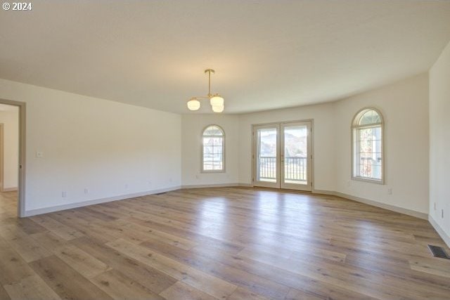 1381 Echo Dr, Roseburg, OR 97470 - unfurnished room with healthy amount of natural light, wood finished floors, baseboards, and a chandelier