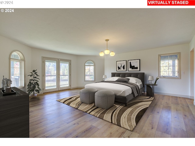 bedroom with access to exterior, a chandelier, and light hardwood / wood-style floors