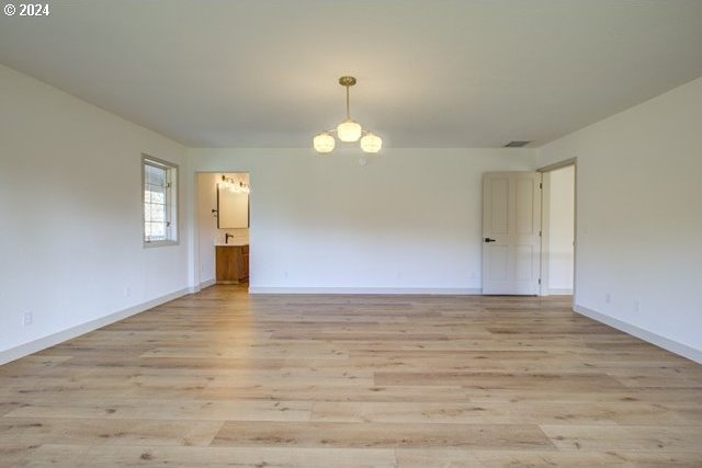 1381 Echo Dr, Roseburg, OR 97470 - unfurnished room featuring light wood finished floors, a chandelier, and baseboards