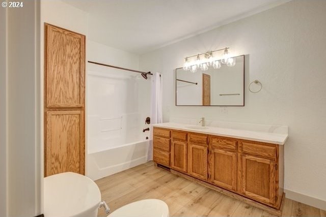 full bathroom featuring toilet, vanity, hardwood / wood-style floors, and bathtub / shower combination