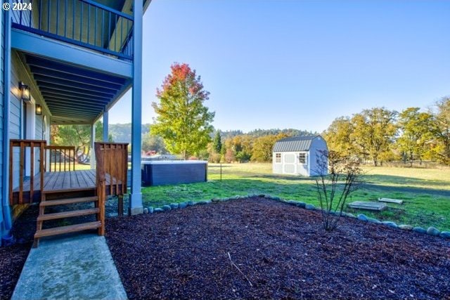 view of yard featuring a balcony and a shed