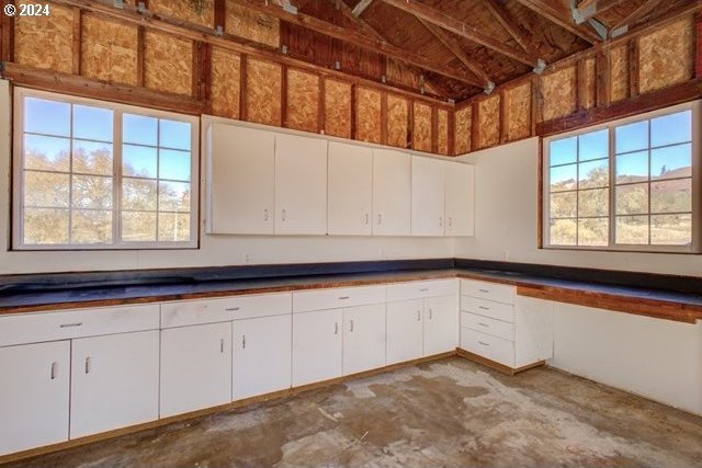 1381 Echo Dr, Roseburg, OR 97470 - kitchen featuring plenty of natural light, white cabinetry, dark countertops, and concrete floors