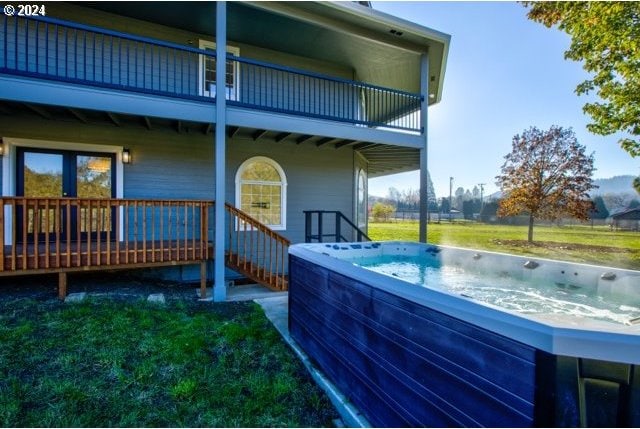 back of property featuring a lawn and a hot tub