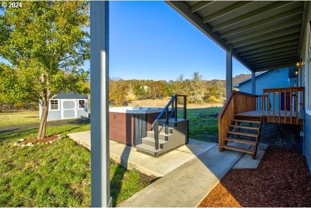 exterior space with a deck, a yard, a storage shed, and a patio area