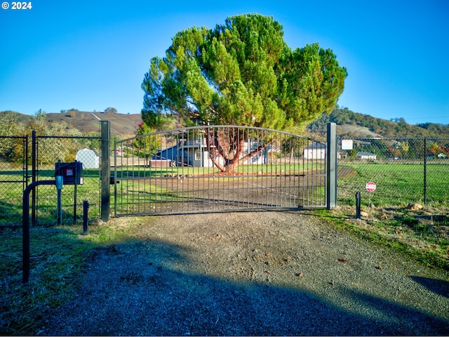 view of gate featuring a lawn and a mountain view