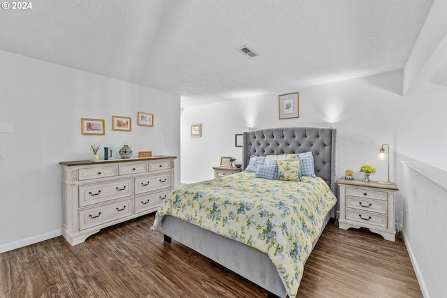 bedroom featuring a textured ceiling, wood finished floors, and baseboards