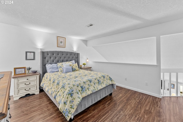 bedroom with wood finished floors, a textured ceiling, baseboards, and vaulted ceiling