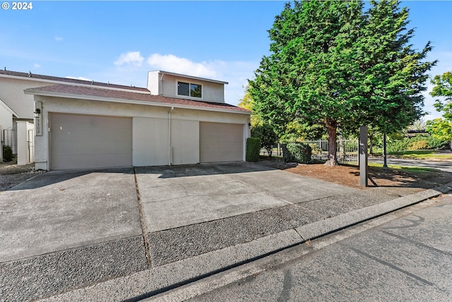 view of front of property featuring stucco siding, driveway, and an attached garage