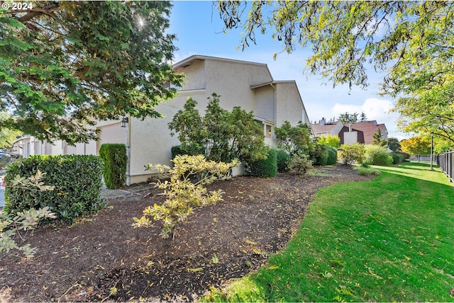 view of side of property with stucco siding and a lawn