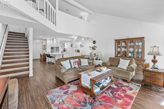 living room with wood finished floors, stairs, beamed ceiling, and high vaulted ceiling