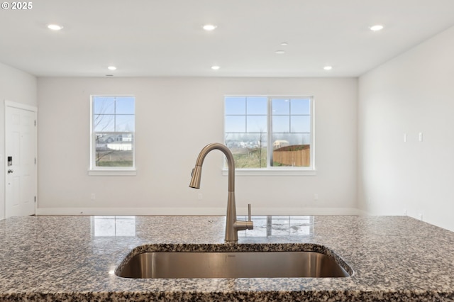 kitchen featuring dark stone countertops and sink