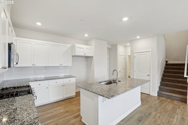 kitchen featuring sink, white cabinetry, a kitchen island with sink, and appliances with stainless steel finishes