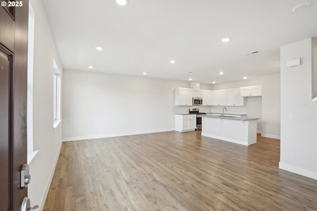 unfurnished living room with sink and light wood-type flooring