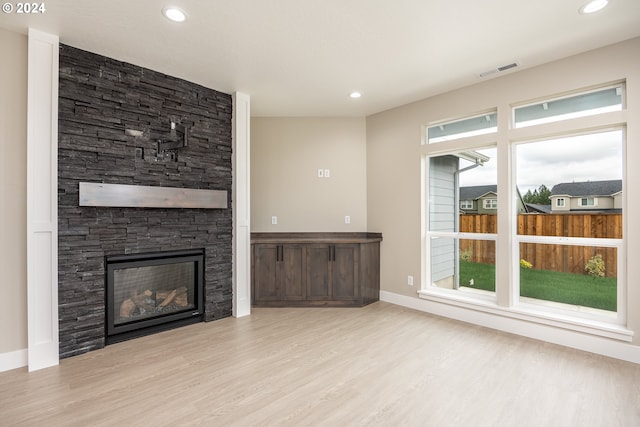 unfurnished living room with a fireplace and light hardwood / wood-style floors