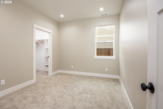 unfurnished room featuring light colored carpet