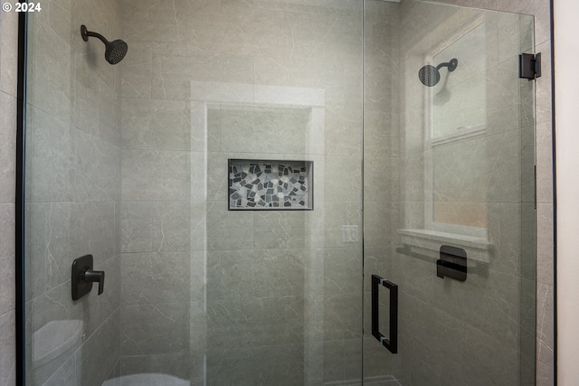 bathroom with a shower with shower door and toilet