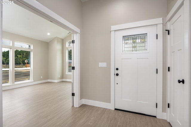 foyer with vaulted ceiling and light wood-type flooring