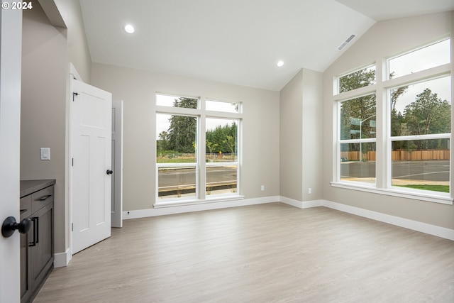 interior space with a healthy amount of sunlight, light hardwood / wood-style floors, and vaulted ceiling