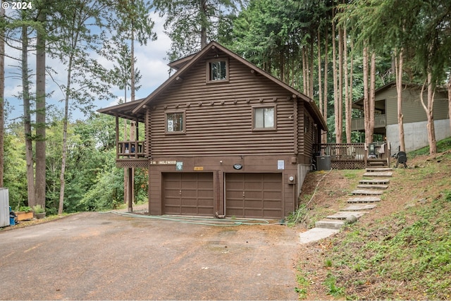 view of side of home with a wooden deck, central AC unit, and a garage