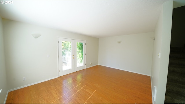 spare room with french doors and hardwood / wood-style flooring