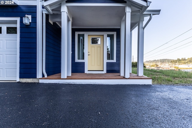 property entrance with a porch and a garage