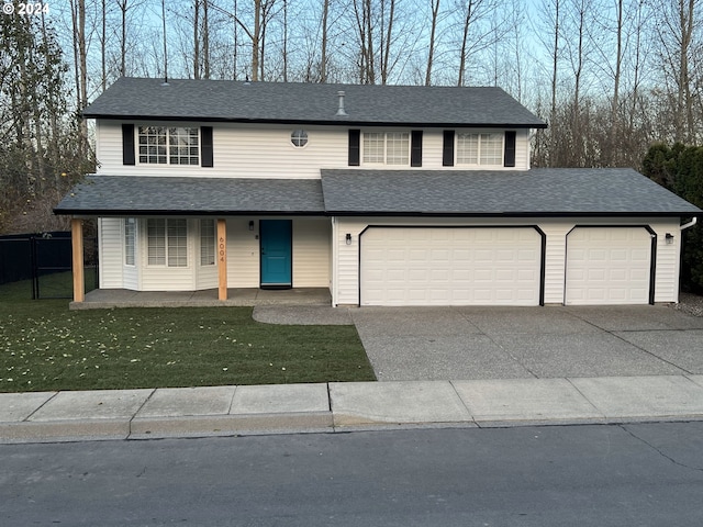 view of property featuring a front lawn, a porch, and a garage