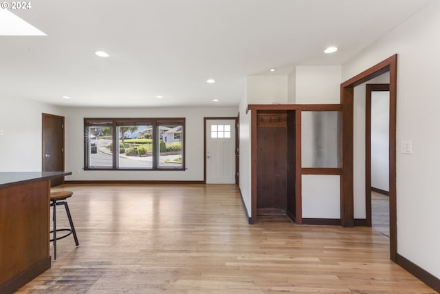 entrance foyer featuring light hardwood / wood-style floors and a skylight