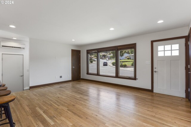 entryway featuring a wall unit AC and light hardwood / wood-style flooring