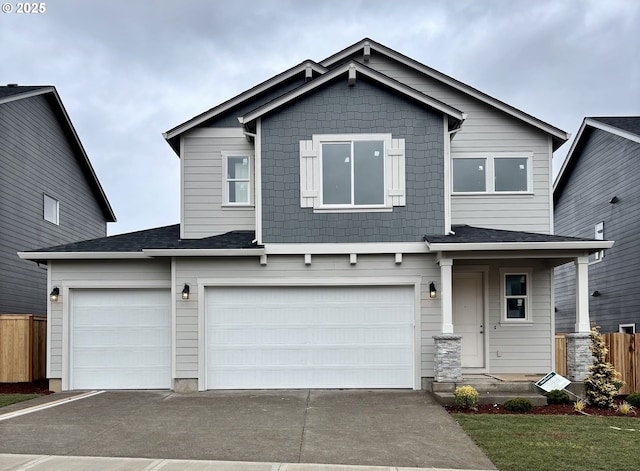 view of front facade featuring a garage, concrete driveway, and fence