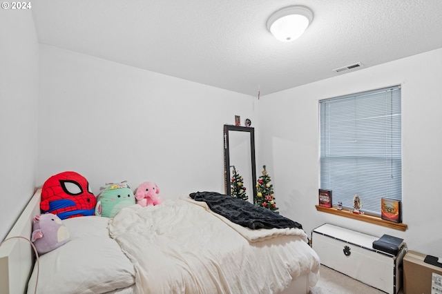 bedroom with carpet floors and a textured ceiling