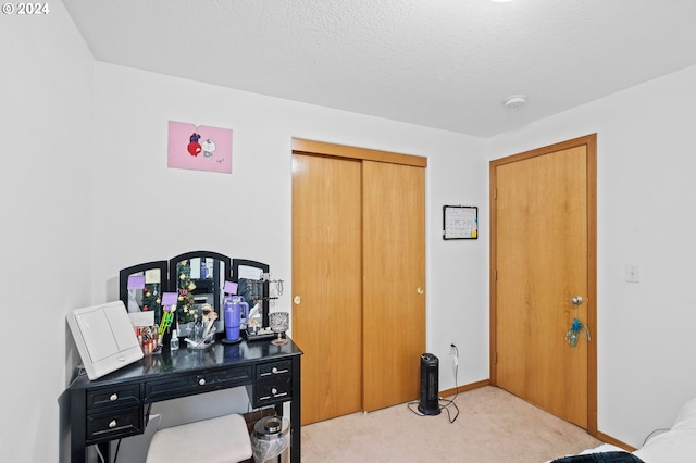 bedroom featuring a closet, light colored carpet, and a textured ceiling