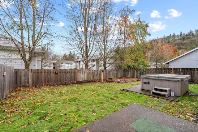 view of yard featuring a wooden deck and a hot tub