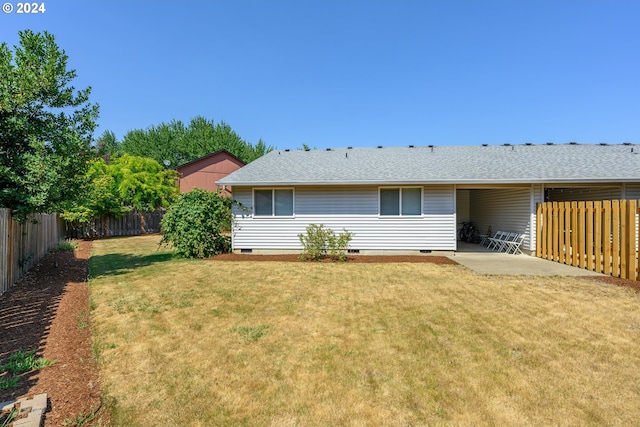 rear view of property featuring a patio area and a lawn