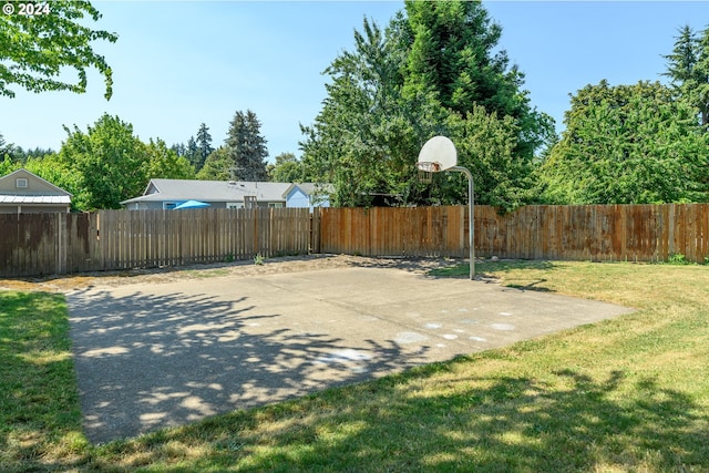 view of sport court with a yard