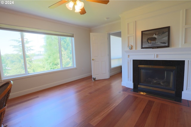 unfurnished living room with hardwood / wood-style flooring, ceiling fan, and crown molding