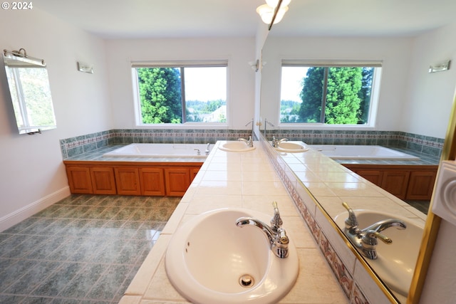 bathroom with vanity, a wealth of natural light, and a tub