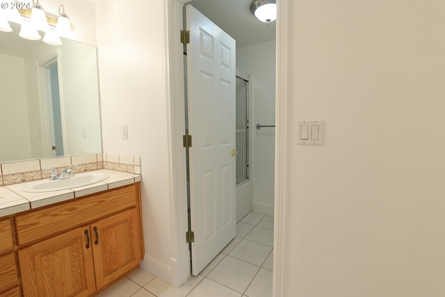 bathroom featuring tile patterned floors, vanity, and shower / bath combination with glass door