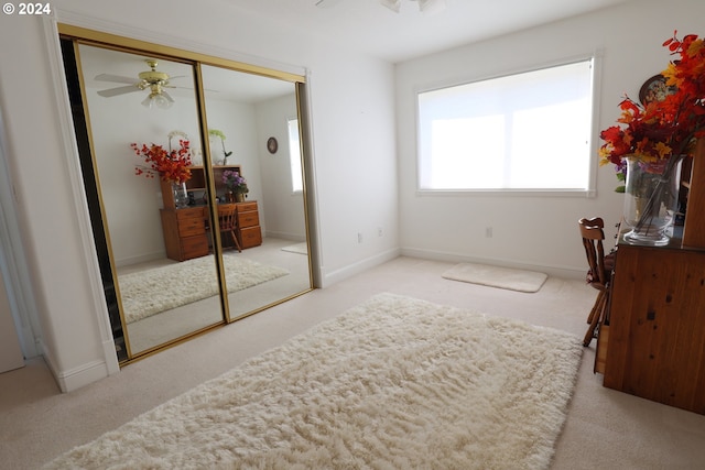 carpeted bedroom featuring a closet and ceiling fan