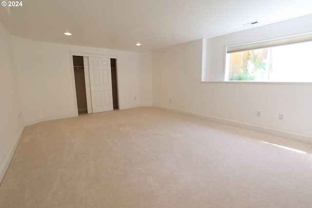 unfurnished bedroom featuring a closet and light colored carpet