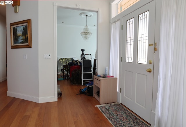 foyer with wood-type flooring and a chandelier