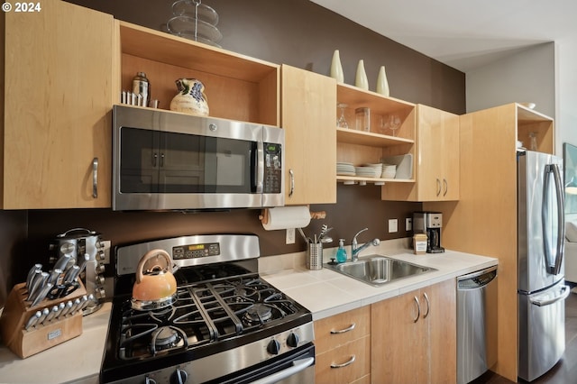 kitchen with open shelves, tile countertops, stainless steel appliances, and a sink