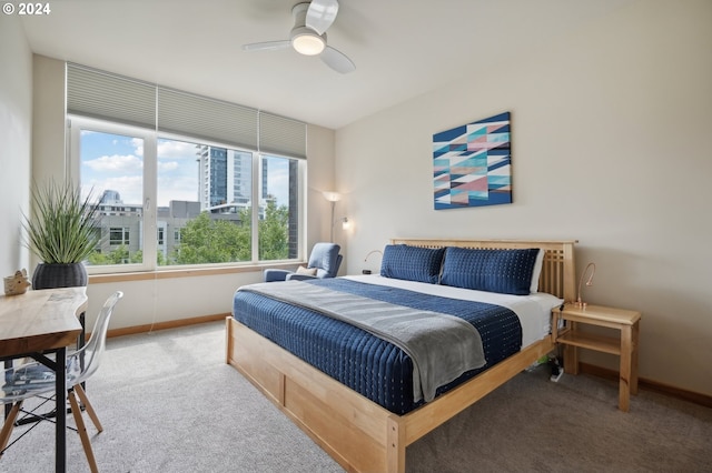 carpeted bedroom featuring ceiling fan, baseboards, and a city view