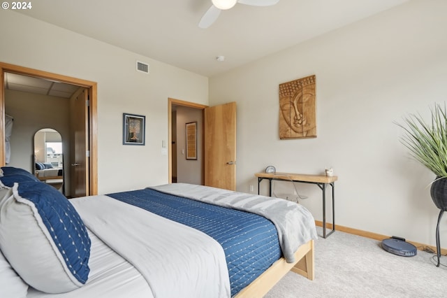 carpeted bedroom featuring ceiling fan, baseboards, visible vents, and arched walkways