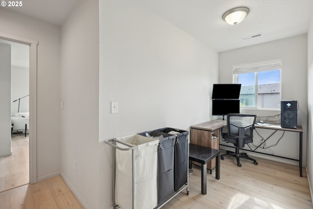 office area featuring baseboards, light wood-style flooring, and visible vents